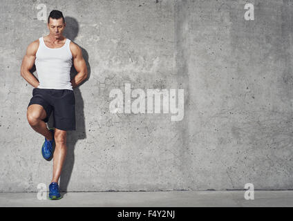 Fit and healthy man, muscular build portrait, fitness concept with copy space on grey background Stock Photo