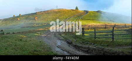 Daybreak haze clouds on hill top and dirty road (Carpathian mountain ...