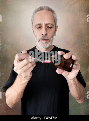 A mature man is pouring cough syrup in a spoon to cure his sore throat and bronchitis Stock Photo