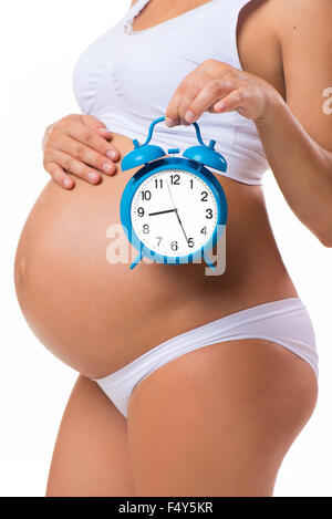 Soon birth. Pregnant belly with alarm clock. Conceptual image of happy pregnancy. Stock Photo