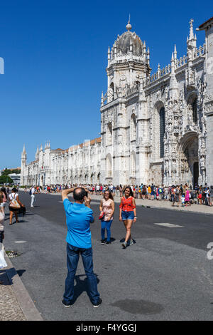 Tourists having their photo taken in front of the Jer nimos Monastery and Church of Santa Maria of Belem Lisbon Portugal Stock Photo