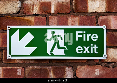 Fire exit sign on the red clay brick wall Stock Photo