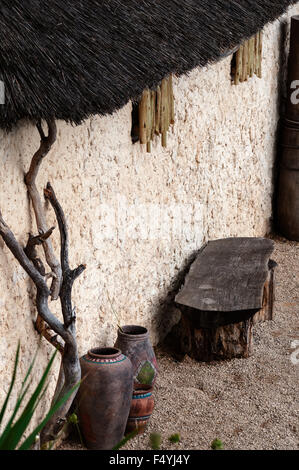 African village outdoor scene empty bench and pots straw roof Stock Photo