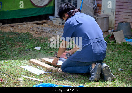 Man use cutting machine cut quarry tile at garden August 29, 2015 in Phrae, Thailand Stock Photo