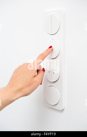 closeup of woman's hand on a light switch Stock Photo