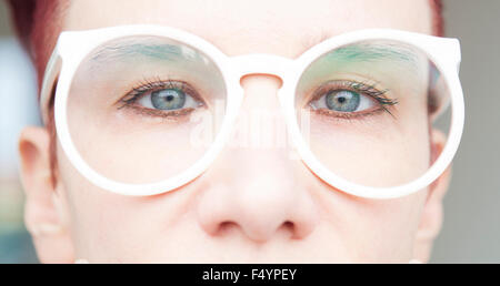 closeup of red-haired woman with white eyeglasses Stock Photo