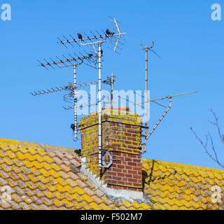 TV antennas (television aerials) on a chimney stack on a house in England, UK. Stock Photo