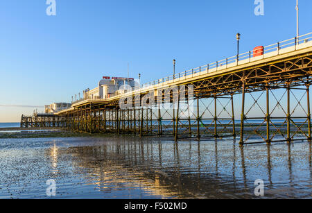 Worthing Pier at low tide early in the morning, with reflections in the wet sand, in Worthing, West Sussex, England, UK. Stock Photo