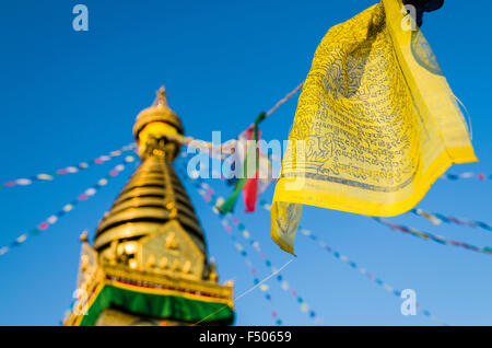 Yellow buddhist prayer flag with Swayambhunath Stupa, the Monkey Temple, in the background Stock Photo