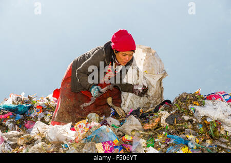Woman sorting out garbage at Aletar garbage dump, earning 300-400 nepali rupees a day Stock Photo