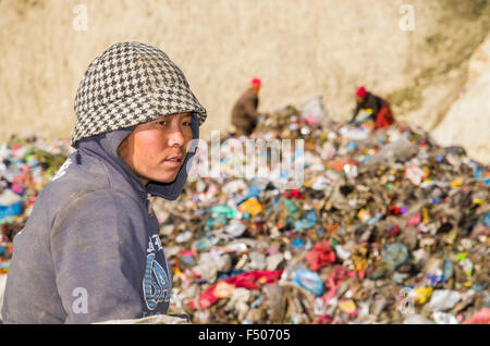 Portrait of a woman sorting out garbage at Aletar garbage dump, 2 more workers in the back Stock Photo