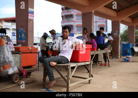 Asian teenage boy relaxing on table against orange ice box in Sisophon Cambodia Stock Photo