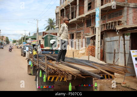 Man delivering reinforcement iron to a building place in Sisophon Cambodia Stock Photo