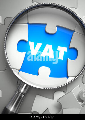 VAT - Value Added Tax - Word on the Place of Missing Puzzle Piece through Magnifier. Selective Focus. Stock Photo