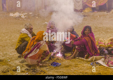 5 out of millions of people gathering at Kumbha Mela ground, sitting around a campfire Stock Photo