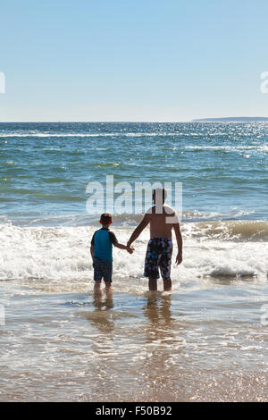 A father holding his son's hand and looking out to see, rear view, concept of fatherhood, USA Stock Photo