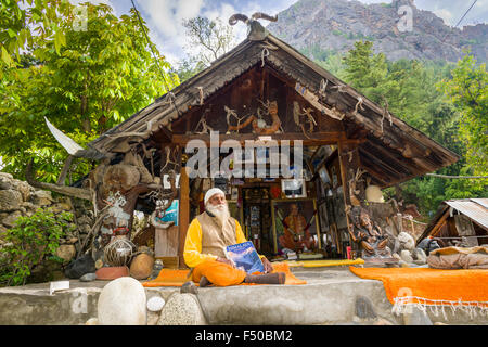 Swami Sundaranand, a famous Sadhu, yogi and photographer, is sitting in front of his house and displaying his book Stock Photo