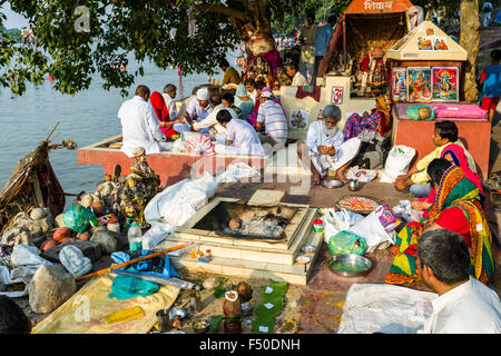 A group of pilgrims at the banks of the river Ganges is performing Ganga Pooja, a religious ceremony Stock Photo