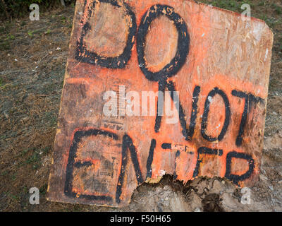 A makeshift 'do not enter' sign written on a broken down piece of particle board Stock Photo