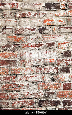 Old uneven decayed whitewashed shabby brick wall as abstract texture background Stock Photo