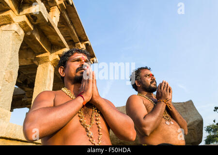 Two Devotees are praying at the Temples on Hemakuta Hill, a part of the ruins of the former Vijayanagara Empire, which was estab