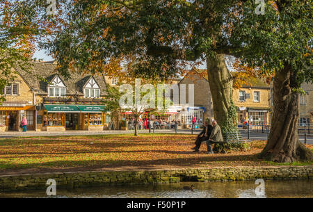 Bourton on the Water, a rural village in the Cotswolds on a sunny Autumn day with two gentlemen in conversation Stock Photo