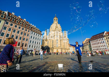 A man is creating big bubbles on Neumarkt in front of the Church of our Lady in the old part of town Stock Photo