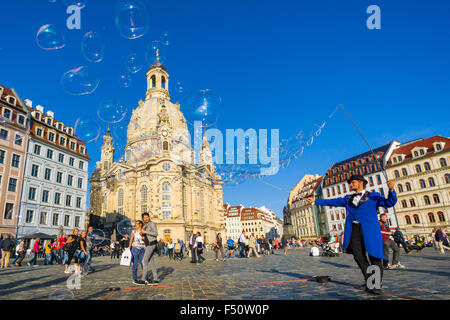 A man is creating big bubbles on Neumarkt in front of the Church of our Lady in the old part of town Stock Photo