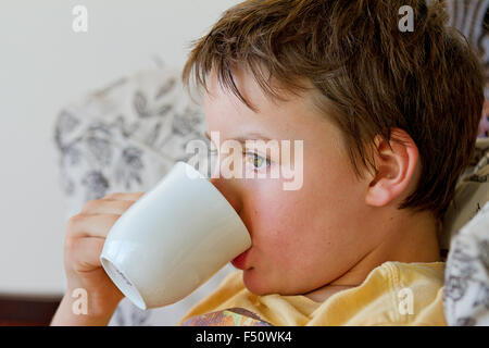 3 year old boy drinking mug of hot chocolate in a cafe Stock Photo - Alamy