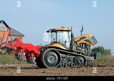 worker repairing the tractor on the field Stock Photo