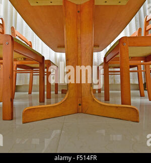 Wooden Dining table and chairs - wide-angle view from floor level. A cat's perspective. Stock Photo