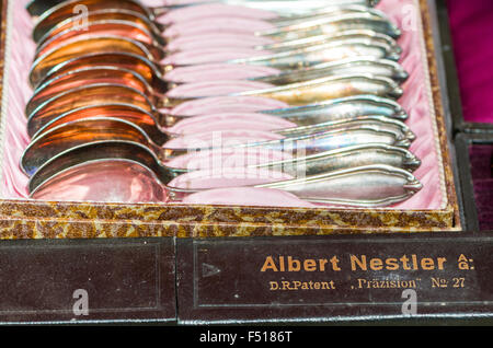 Old silver spoons in a box are offered for sale at the weekly flea market aside the river Elbe Stock Photo