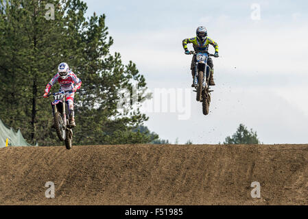 Two motorcyclists on motocross bikes are jumping through the air during training for the MXGP World Championship race Stock Photo