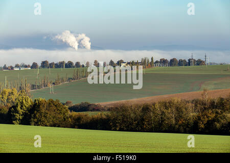 non ecologic smoking chimneys in from factory hidden in morning mist over rural landscape Stock Photo