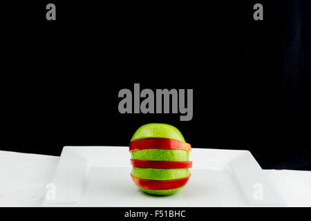 Red and green apple cut into slices Stock Photo