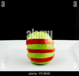 Red and green apple cut into slices Stock Photo