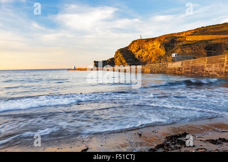 Evening light on the pier and cliffs at Portreath Cornwall England UK Europe Stock Photo