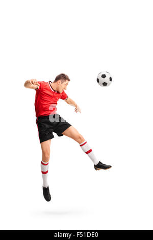 Full length portrait of a young football player heading a ball shot in mid-air isolated on white background Stock Photo