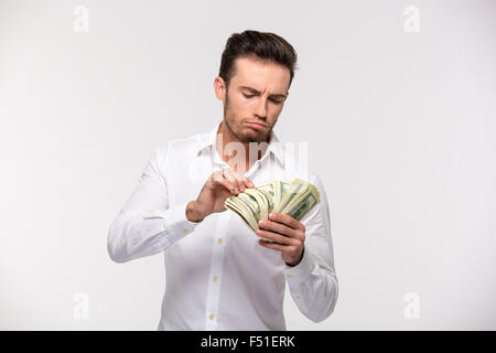 Portrait of a young man counting money isolated on a white background Stock Photo