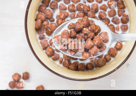 Spoon with chocolate balls and milk view from above Stock Photo