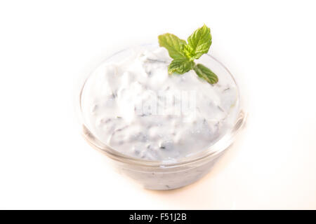 A glass bowl full of tzatsiki, isolated on white background Stock Photo