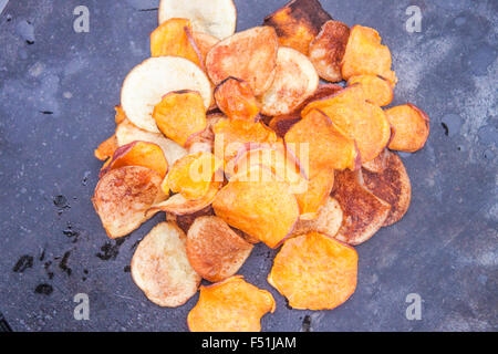 Sweet potato and potato chips, on a stone plate Stock Photo