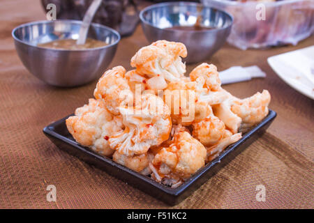 White cauliflowers marinated with sweet chili sauce, waiting to be grilled on a barbeque Stock Photo