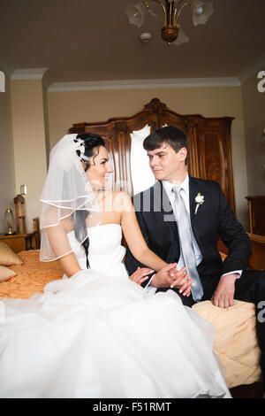 beautiful young  couple sitting on the bed Stock Photo