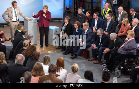 Nuremberg, Germany. 26th Oct, 2015. HANDOUT - A handout dated 26 October 2015 shows German Chancellor Angela Merkel speaking with invited citizens at the 'Gut leben in Deutschland' (lit. living well in Germany) discussion event in Nuremberg, Germany. (L: presenter Tilmann Schoeberl). PHOTO: DANIEL KARMANN/DPA/Alamy Live News Stock Photo