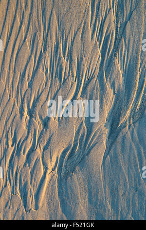 Water patterns on sand with shadows and morning light Stock Photo