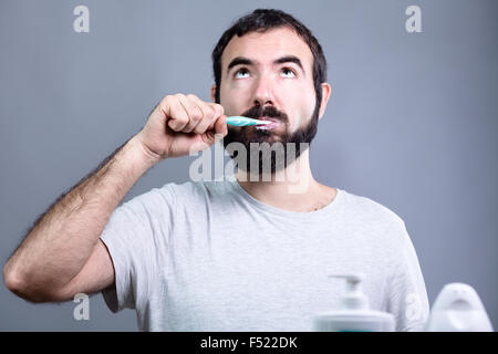 Man with Beard Washing His Teeth with a Toothbrush Stock Photo