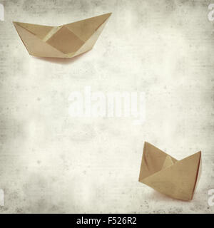 textured old paper background with origami paper boat Stock Photo