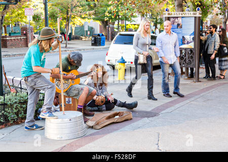 Street musicians busk in front of Pritchard Park in Asheville, North Carolina. Stock Photo