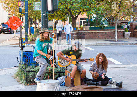 Street musicians busk in front of Pritchard Park in Asheville, North Carolina. Stock Photo